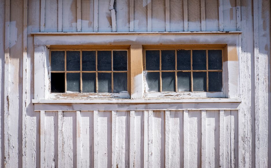 Painted house wall with a window in daylight