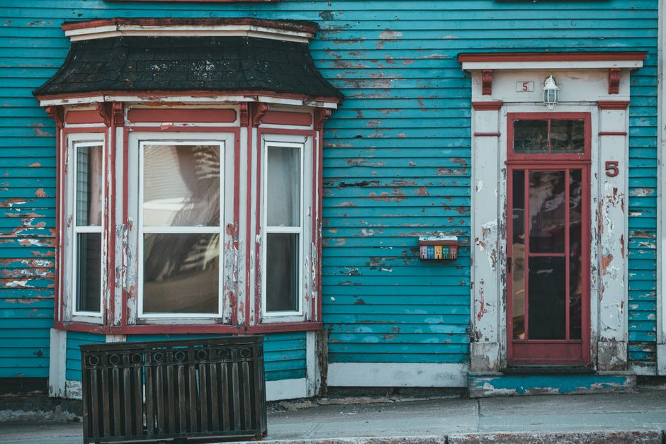 Painted house wall with a window in daylight